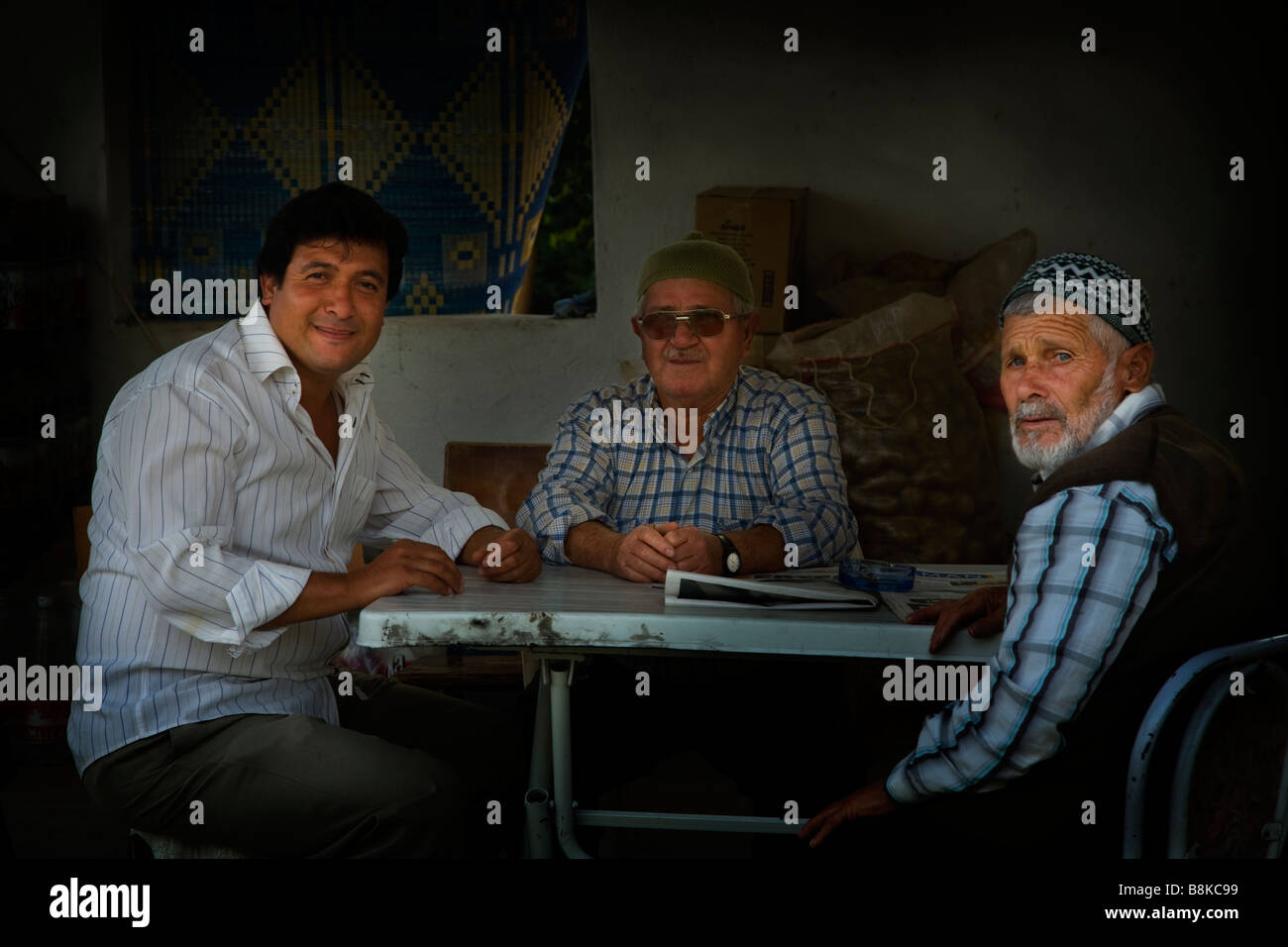 Trois hommes assis à une table dans un café de la chaussée en Turquie Banque D'Images