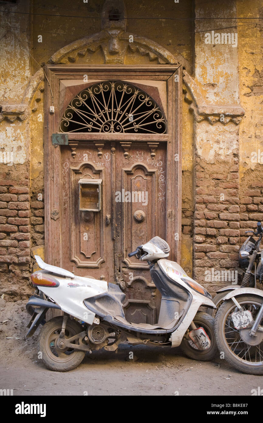 Scooter et moto garée à l'extérieur porte d'entrée d'une maison en Egypte Banque D'Images