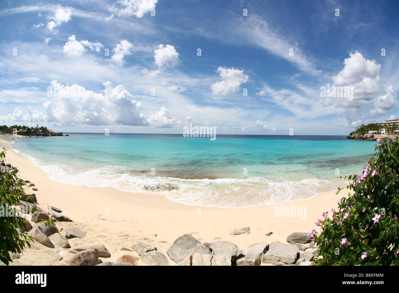 Un paradis plage de sable blanc, la mer d'azur et un ciel bleu avec quelques nuages sur l'île de Saint Martin dans les Antilles néerlandaises Banque D'Images