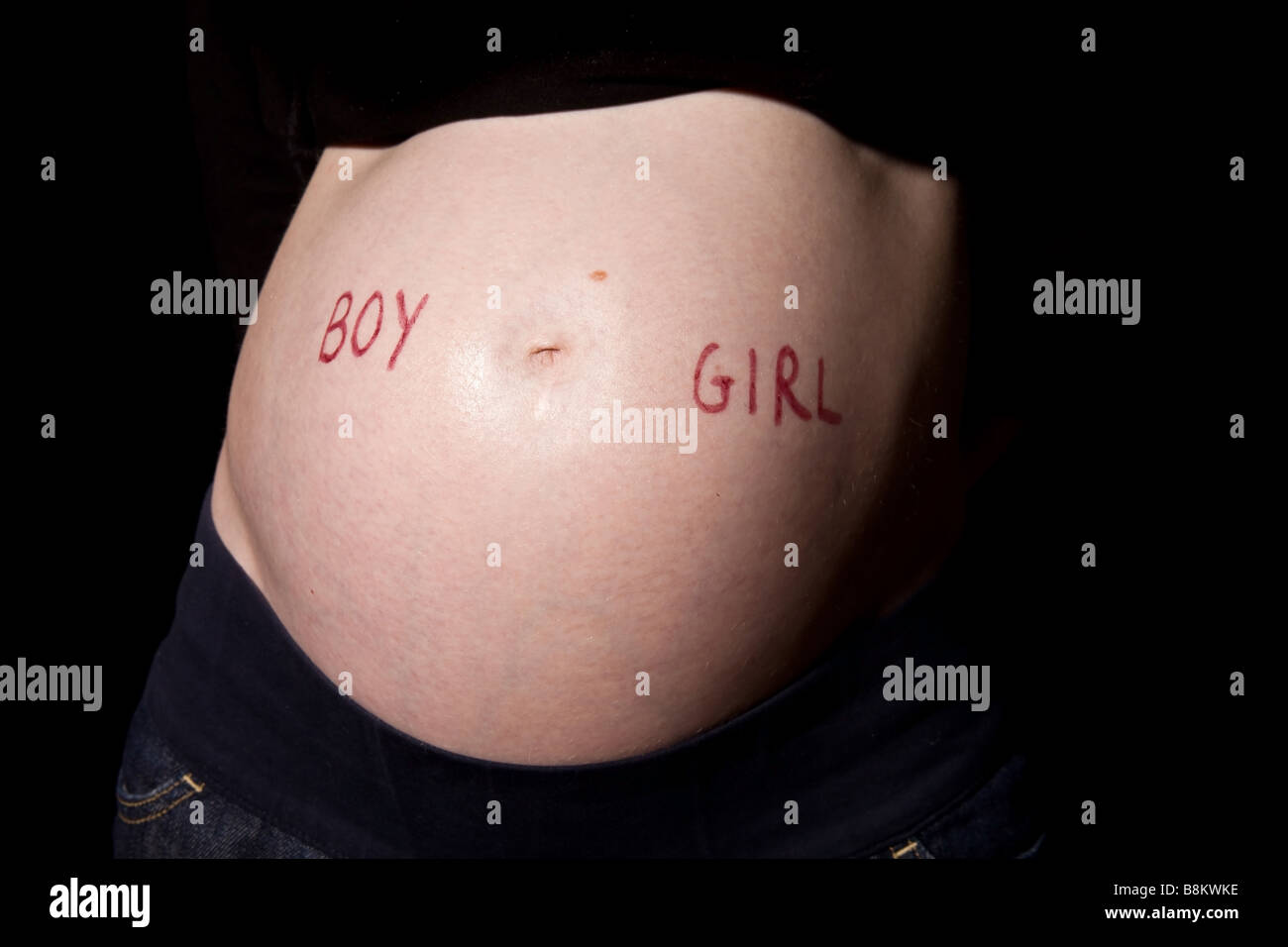 Garçon ou fille ? Écrit sur le ventre d'une femme enceinte de sept mois Banque D'Images