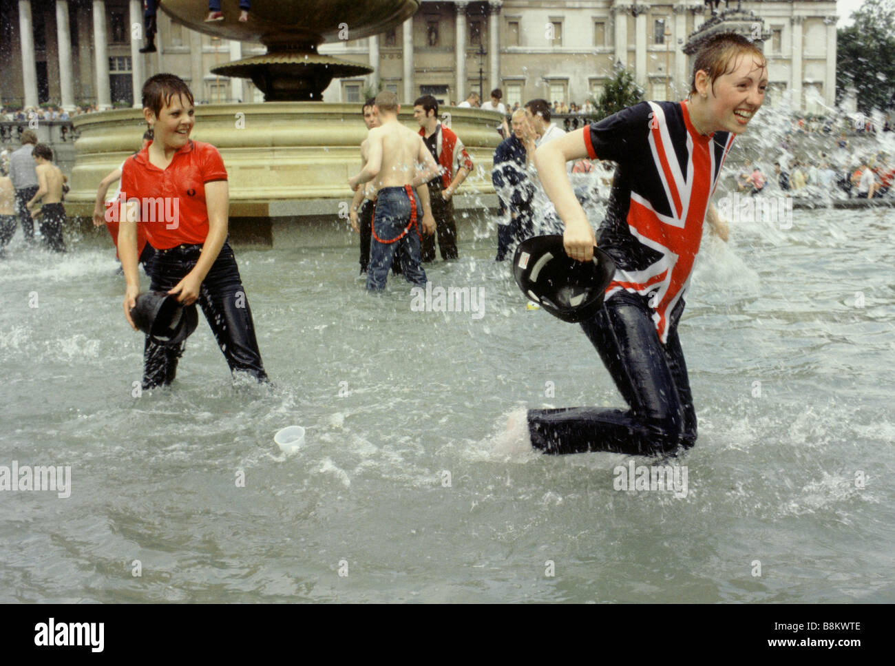 Trafalgar Square London UK Skinheads jouer dans la fontaine à Trafalgar Square le jour du mariage royal Banque D'Images