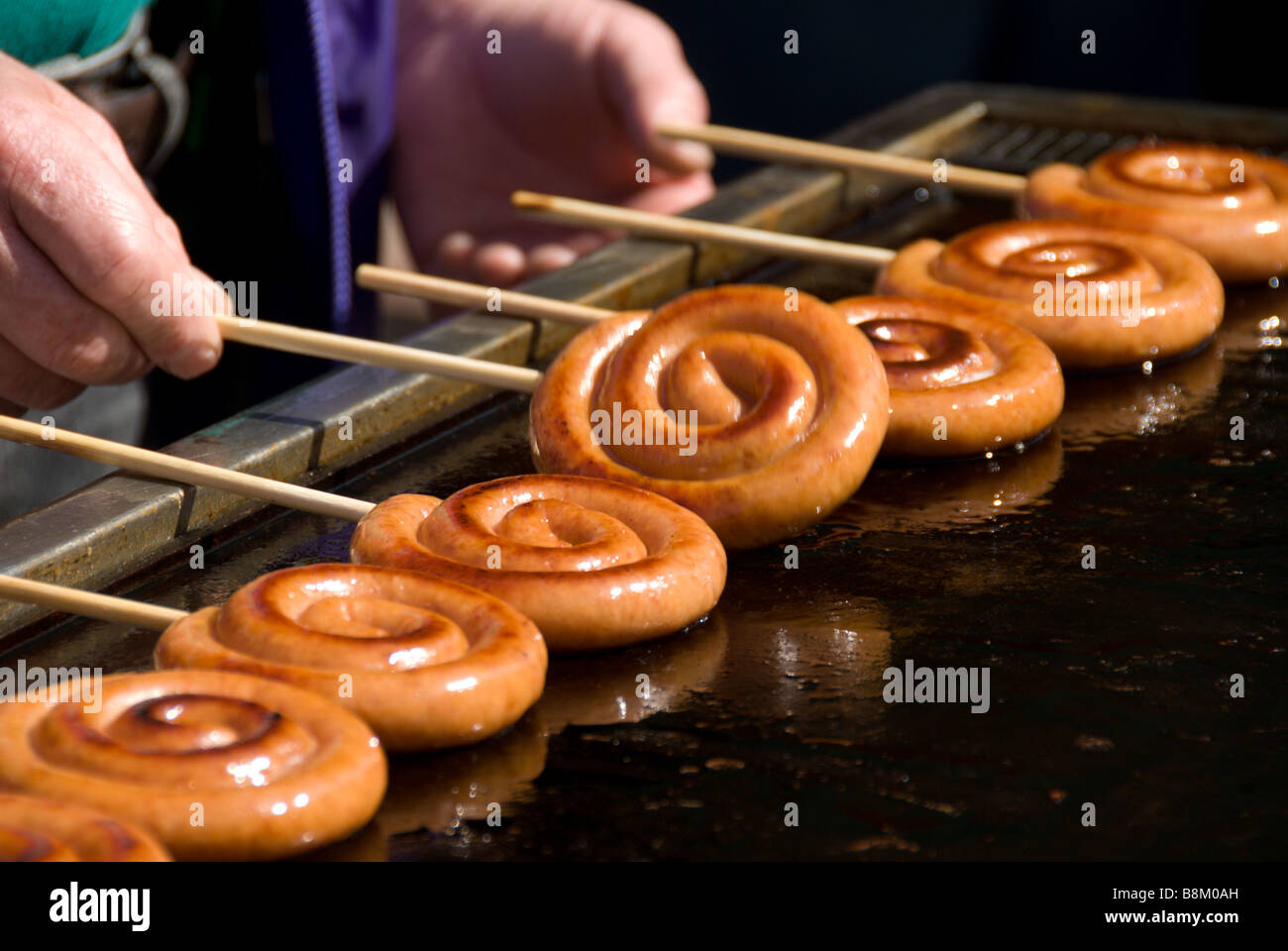 Les saucisses de Francfort depuis longtemps tordu en spirale et un style lollipop grillées sur un bâton pour un festival, Japon Banque D'Images