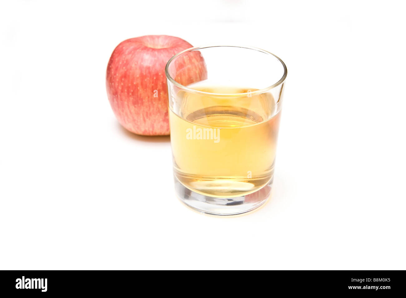 Verre de jus de pomme avec un fuji apple isolated on a white background studio Banque D'Images