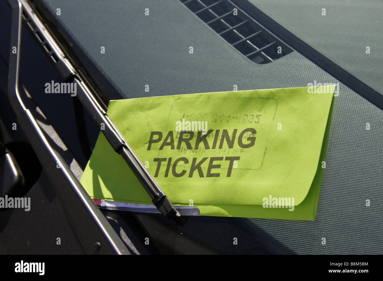 Ticket de parking à gauche sur pare-brise de voiture Banque D'Images