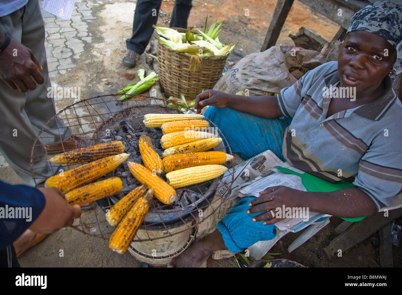 Une femme à Lagos, Nigeria vend rue-maïs grillé. Banque D'Images