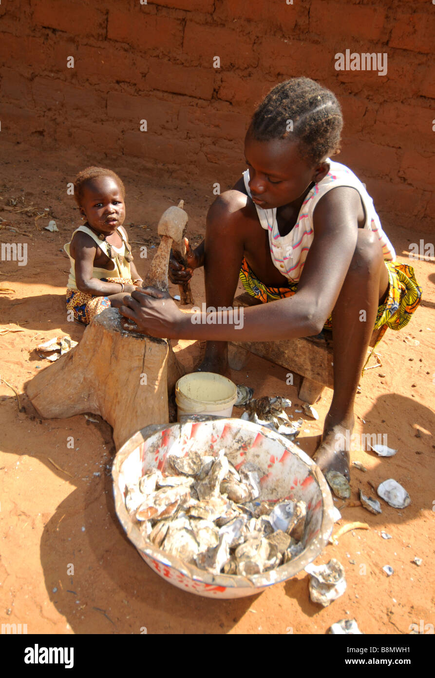 Travail fille ouvrir les huîtres, la Gambie, Afrique de l'Ouest Banque D'Images