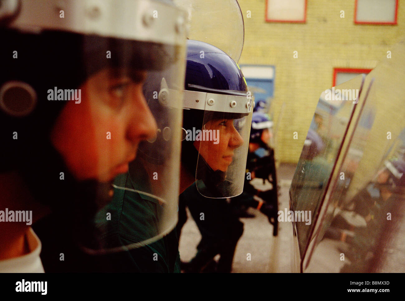 Policiers et policières les femmes soutiennent boucliers lors d'entraînement des chevaux de la police. Banque D'Images