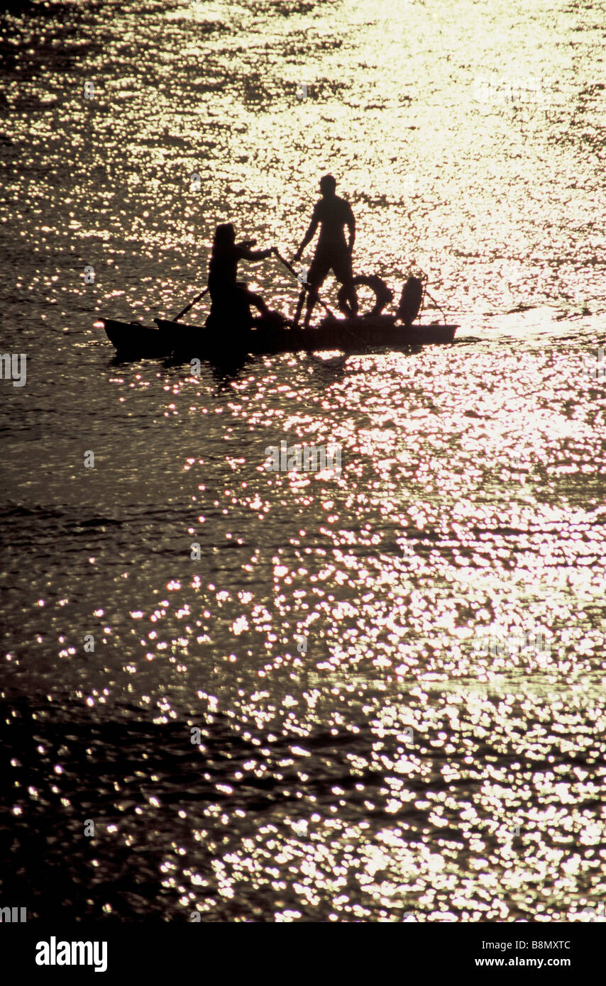 Deux personnes d'un petit bateau de ligne / canoë sur la mer ouverte. Banque D'Images
