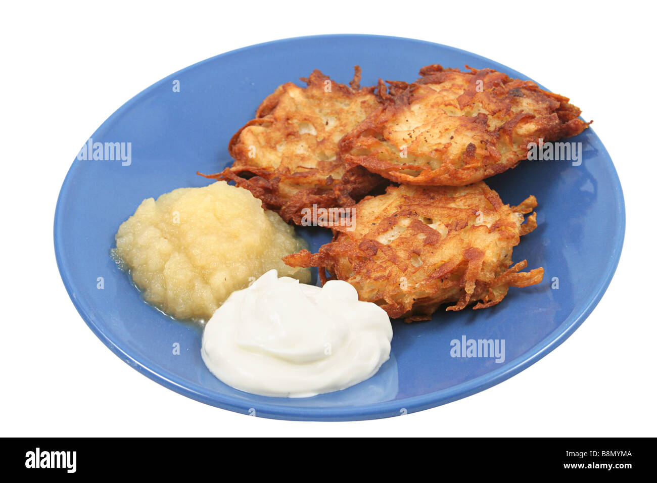 Les galettes de pommes de terre pour les latkes Hanukah servi avec de la crème et la compote Isolated Banque D'Images