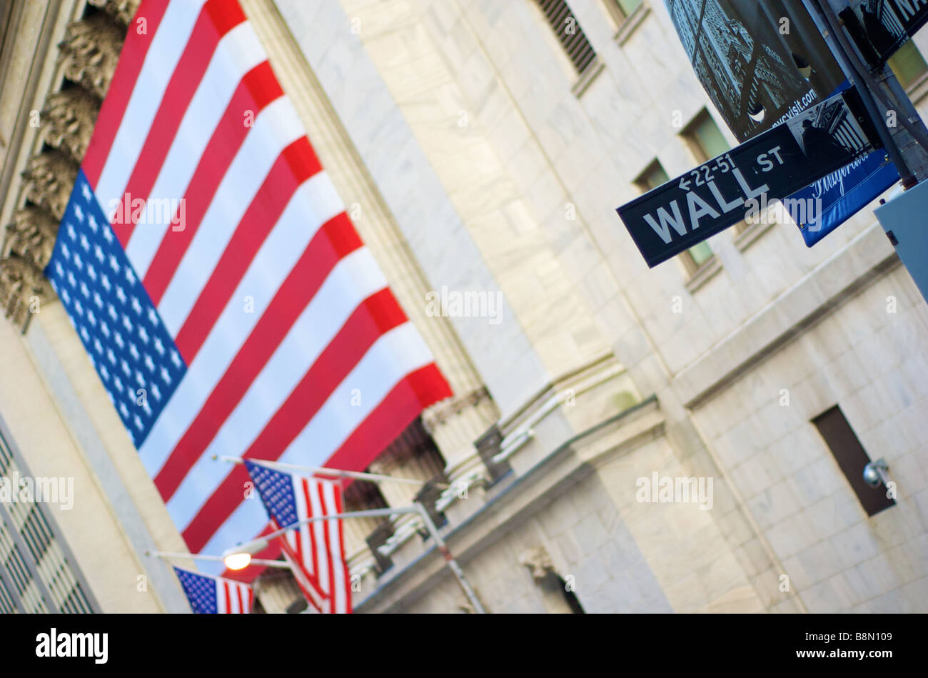 Wall Street signe avec le drapeau américain drapé sur New York Stock Exchange Building à New York, USA (pour un usage éditorial uniquement) Banque D'Images