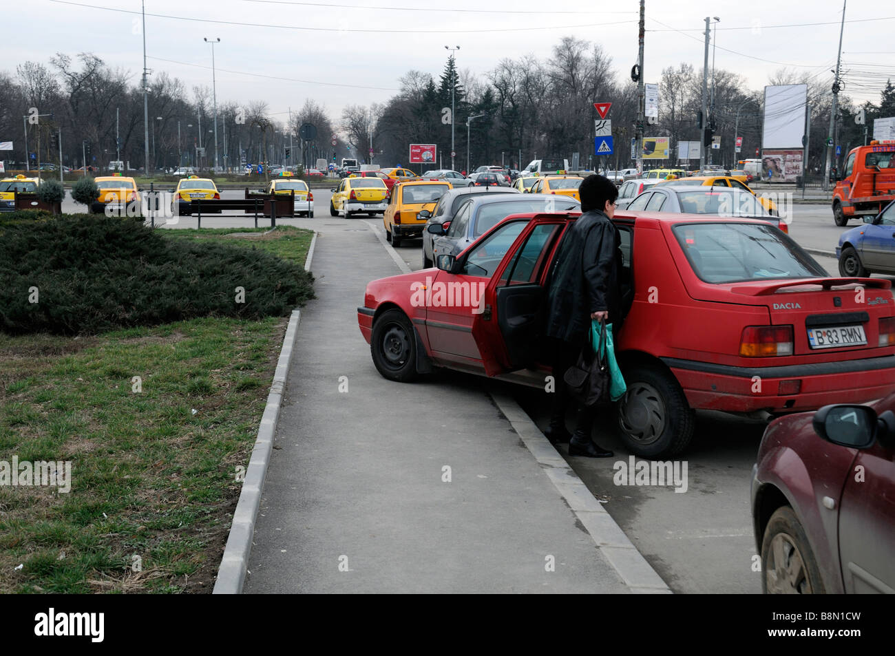 Un exemple de très mauvaise ou inconsidérée parking où une femme a garé sa voiture sur le chemin de la moitié pied stéréotype Banque D'Images