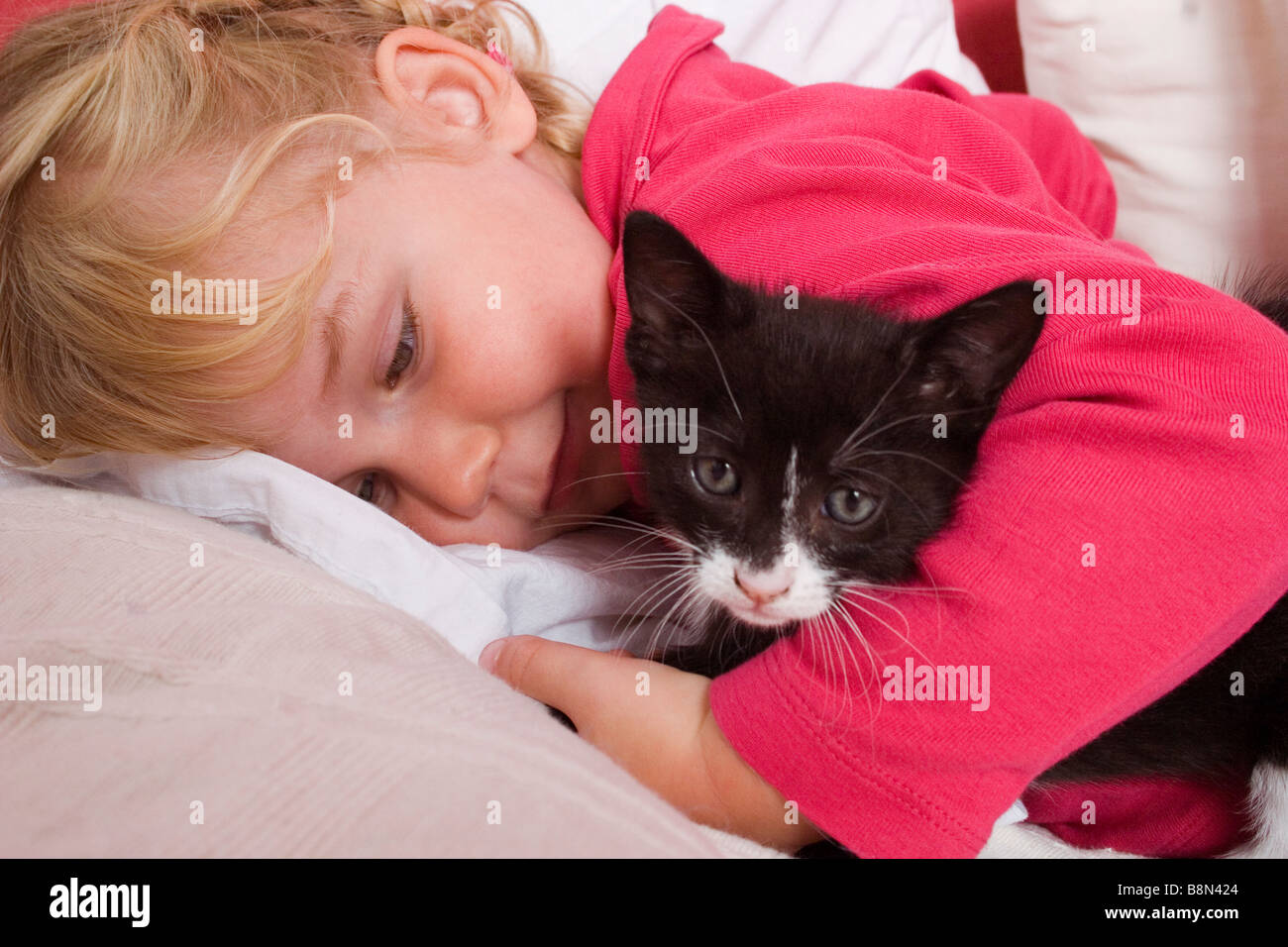 Petite fille jouant avec des tout-petits chaton noir Banque D'Images