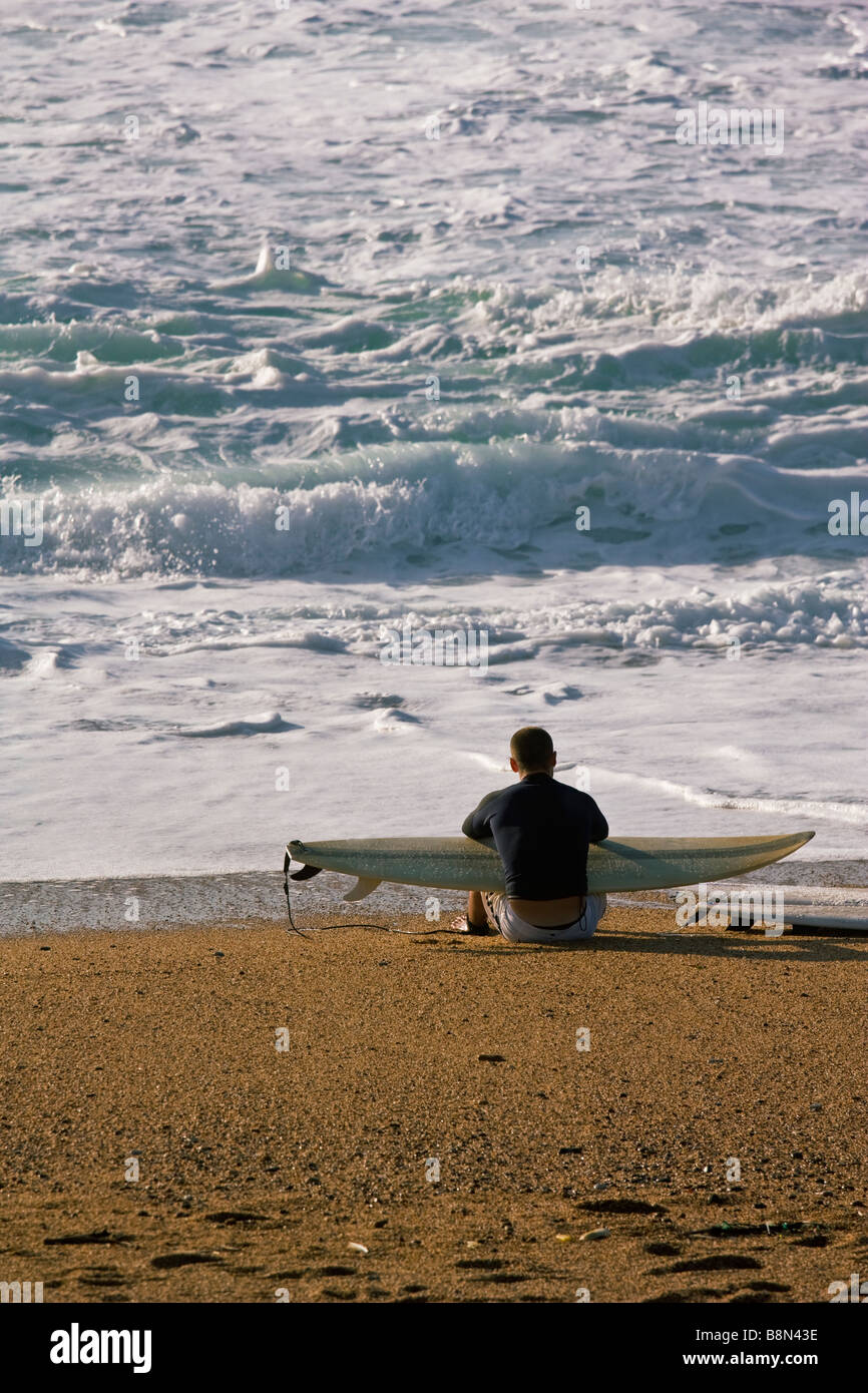 Longboarder regarder les vagues en fin d'après-midi Banque D'Images