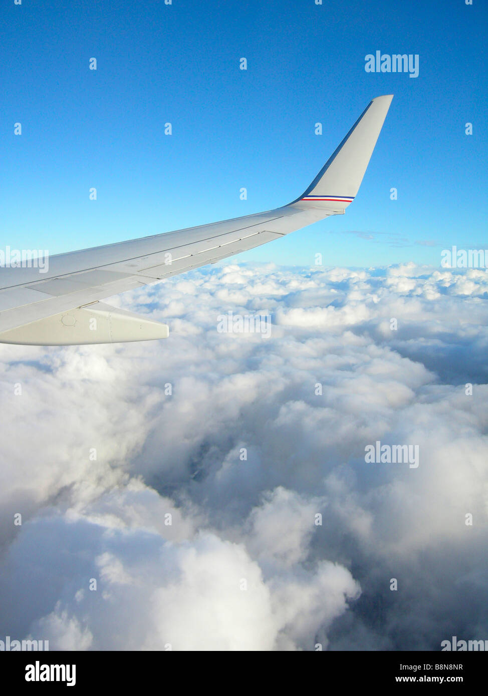 Aile d'avion avec ciel bleu et nuages ci-dessus Banque D'Images