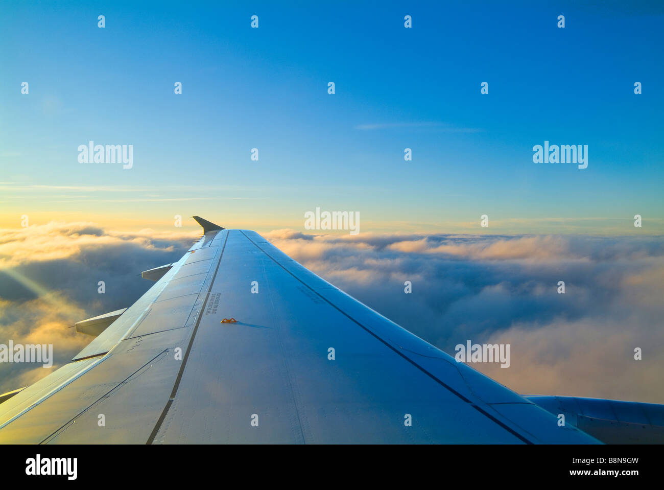 Aile d'avion avec ciel bleu et nuages ci-dessus Banque D'Images