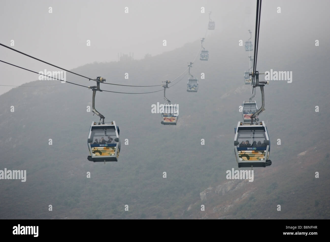 Connue comme la télécabine Skyrail Ngong Ping en un jour brumeux menant à Tian Tan Buddha le Grand Bouddha de l'île de Lantau à Hong Kong Banque D'Images