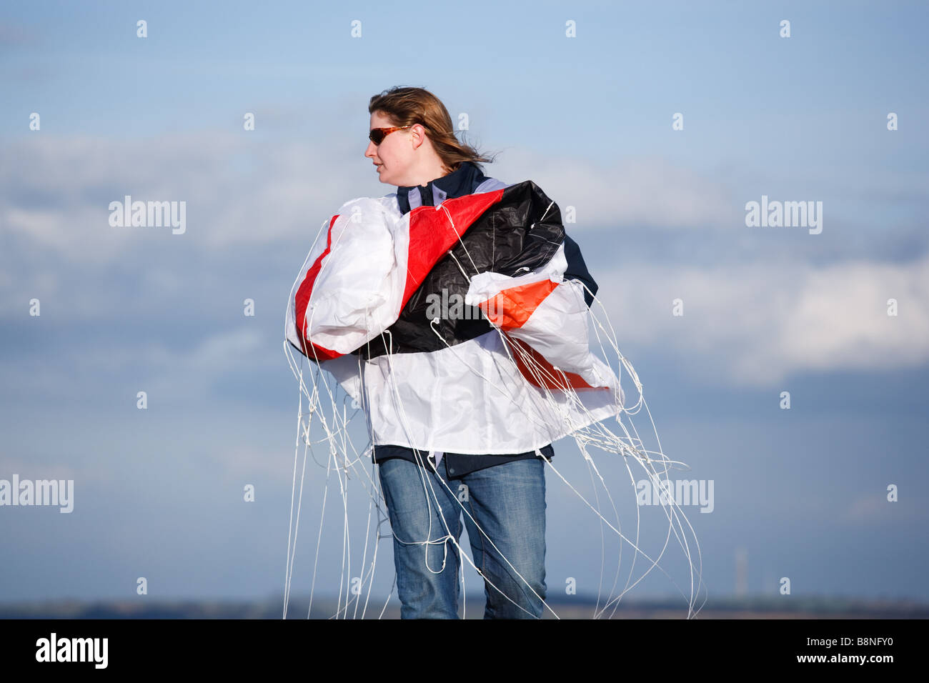 Femme en train de lancer 'cirrus' kite marque sur une colline en Angleterre Banque D'Images
