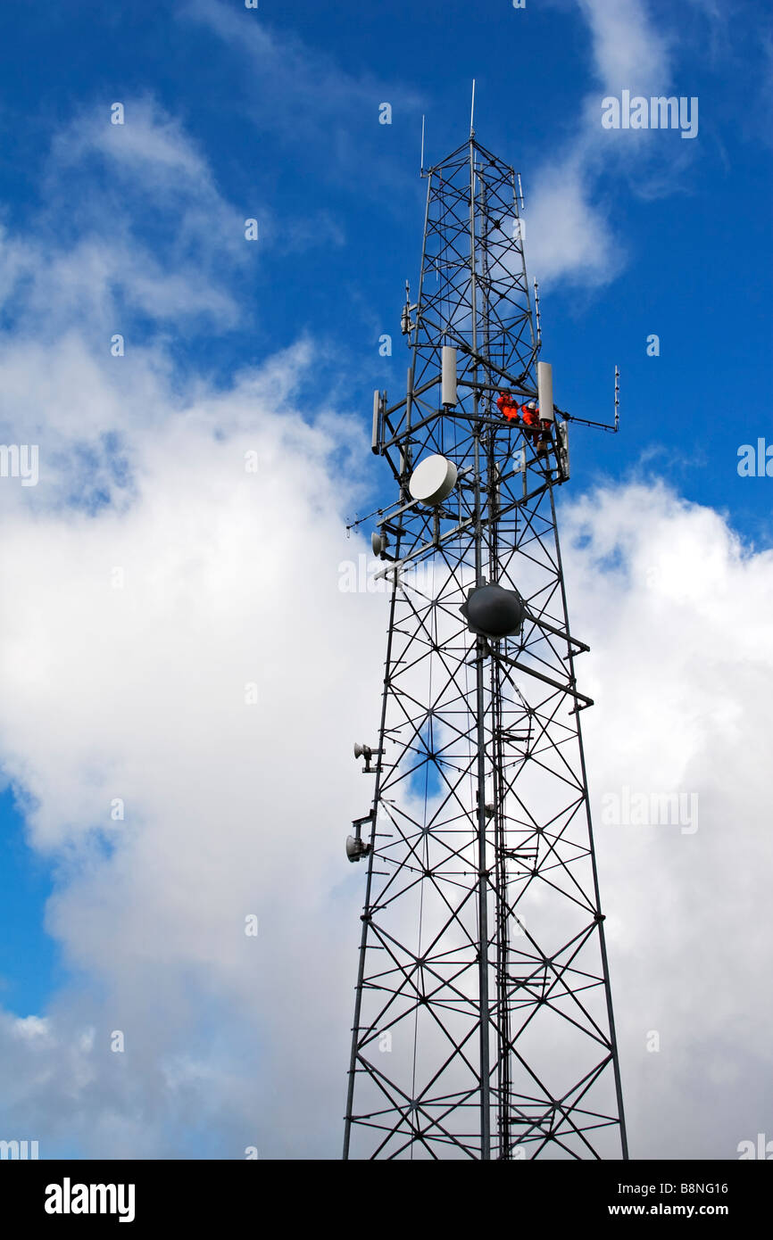2 hommes en salopette orange travailler en hauteur sur un pylône radio  installation et réparation d'antennes Photo Stock - Alamy