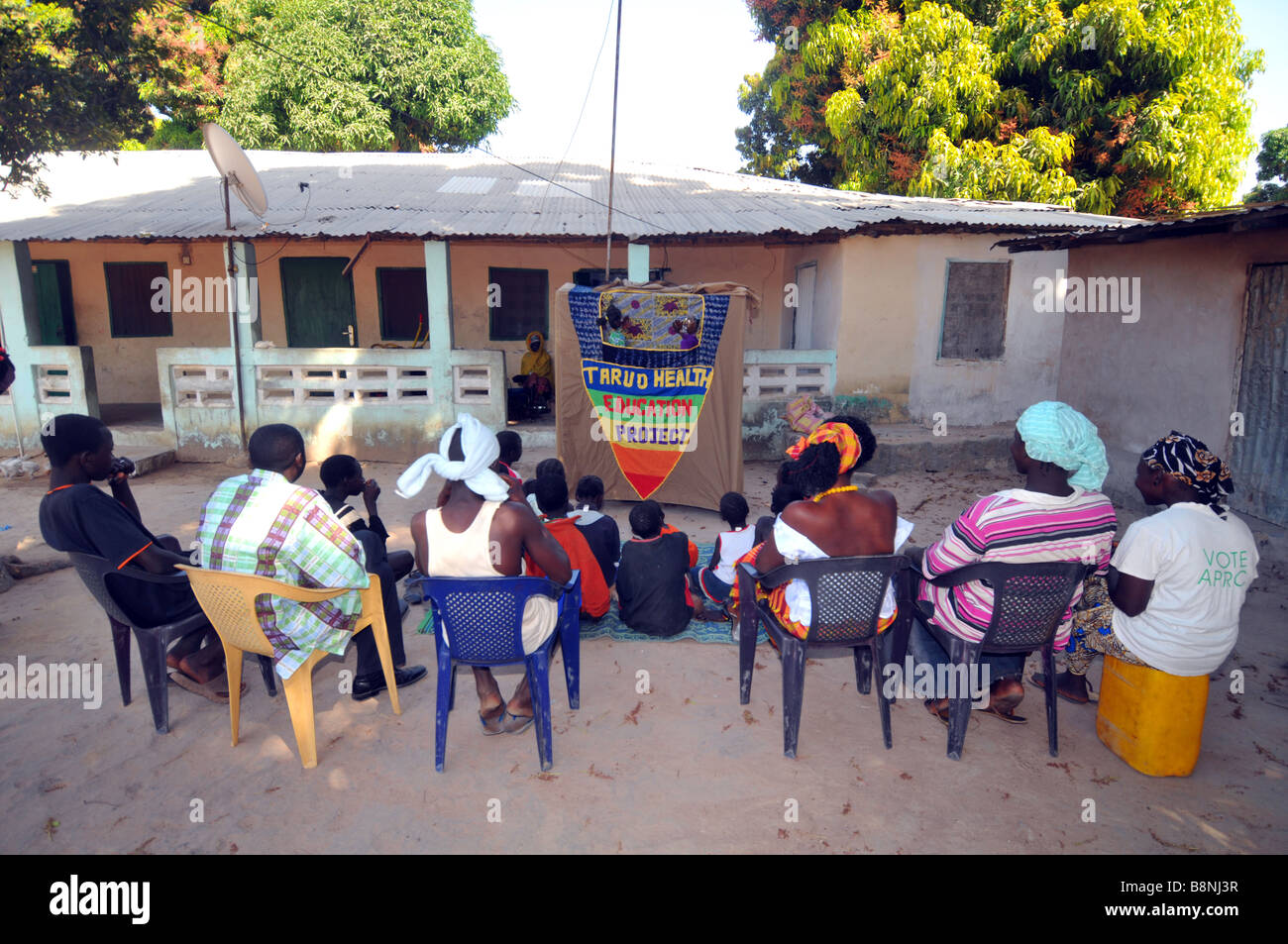 L'éducation en matière de santé villageois regarder un spectacle de marionnettes, la Gambie, Afrique de l'Ouest Banque D'Images