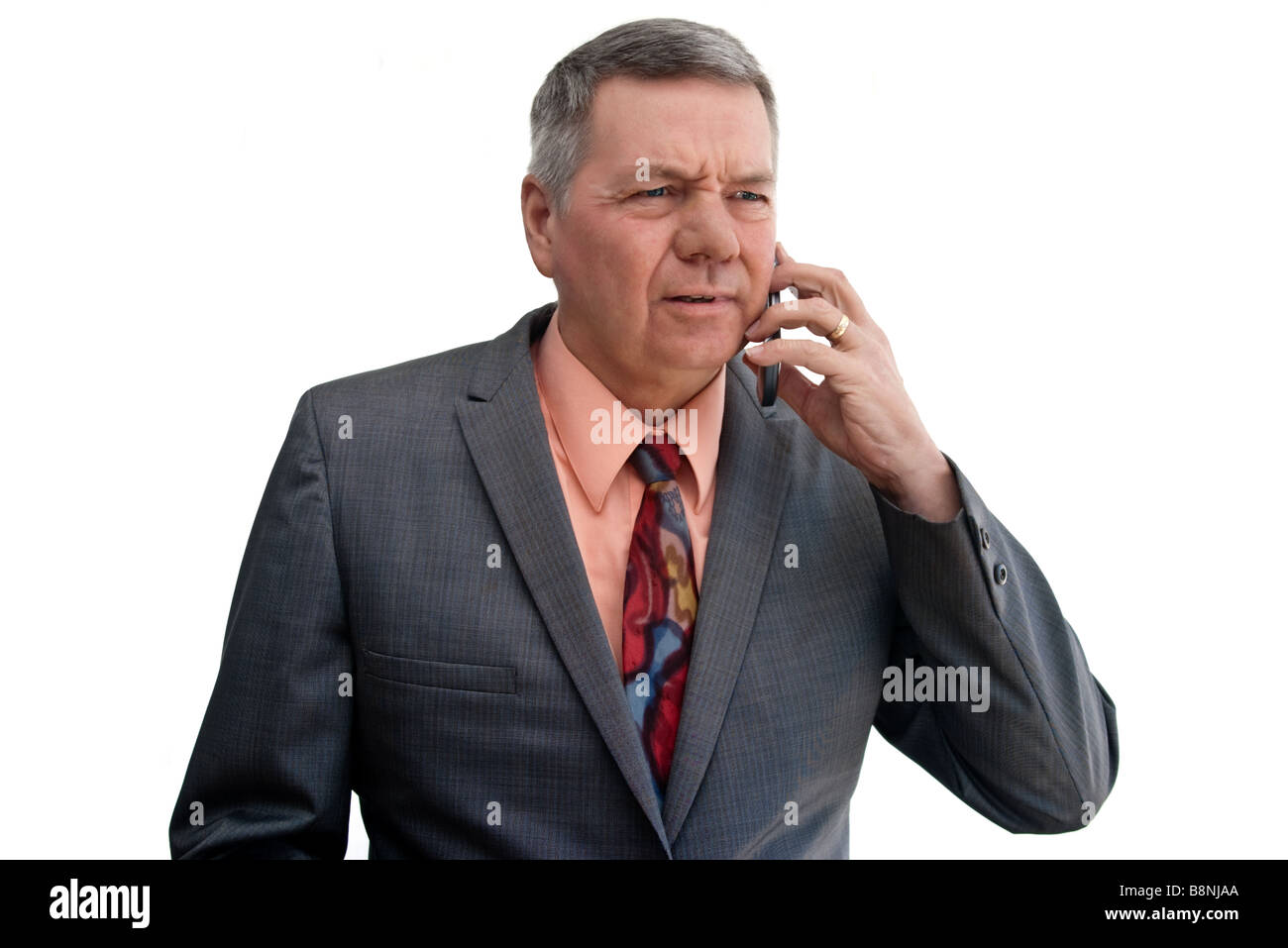 Portrait of a young businessman talking on cell phone avec regard perplexe sur le visage isolé sur fond blanc Banque D'Images
