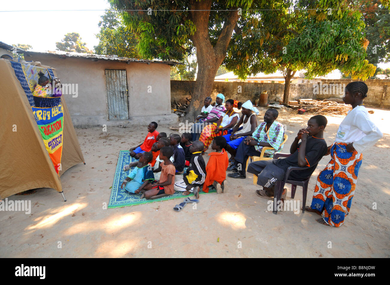L'éducation en matière de santé villageois regarder un spectacle de marionnettes, la Gambie, Afrique de l'Ouest Banque D'Images
