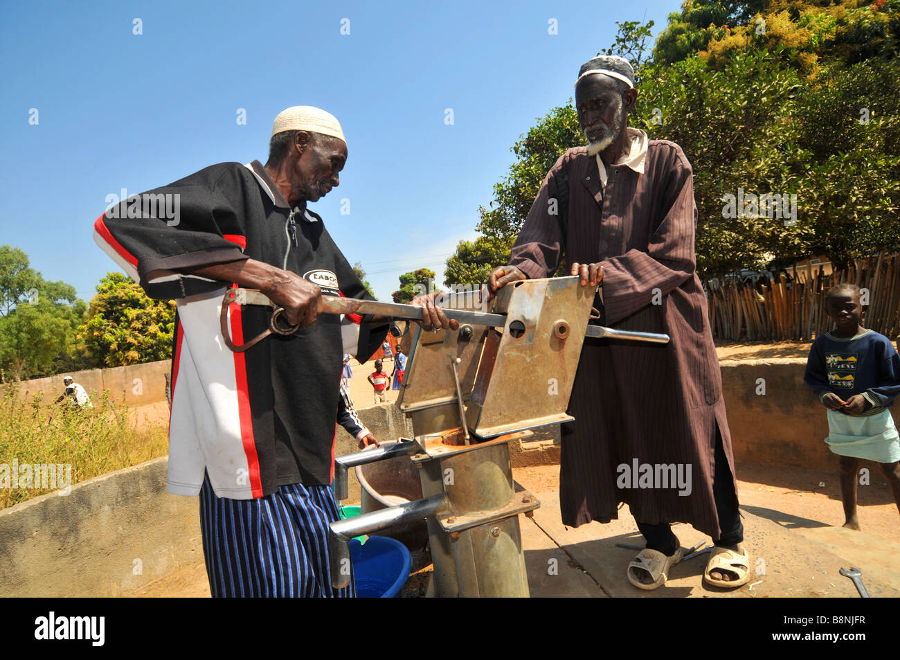 Les hommes de réparer une pompe à eau dans un village de la Gambie, Afrique de l'Ouest Banque D'Images