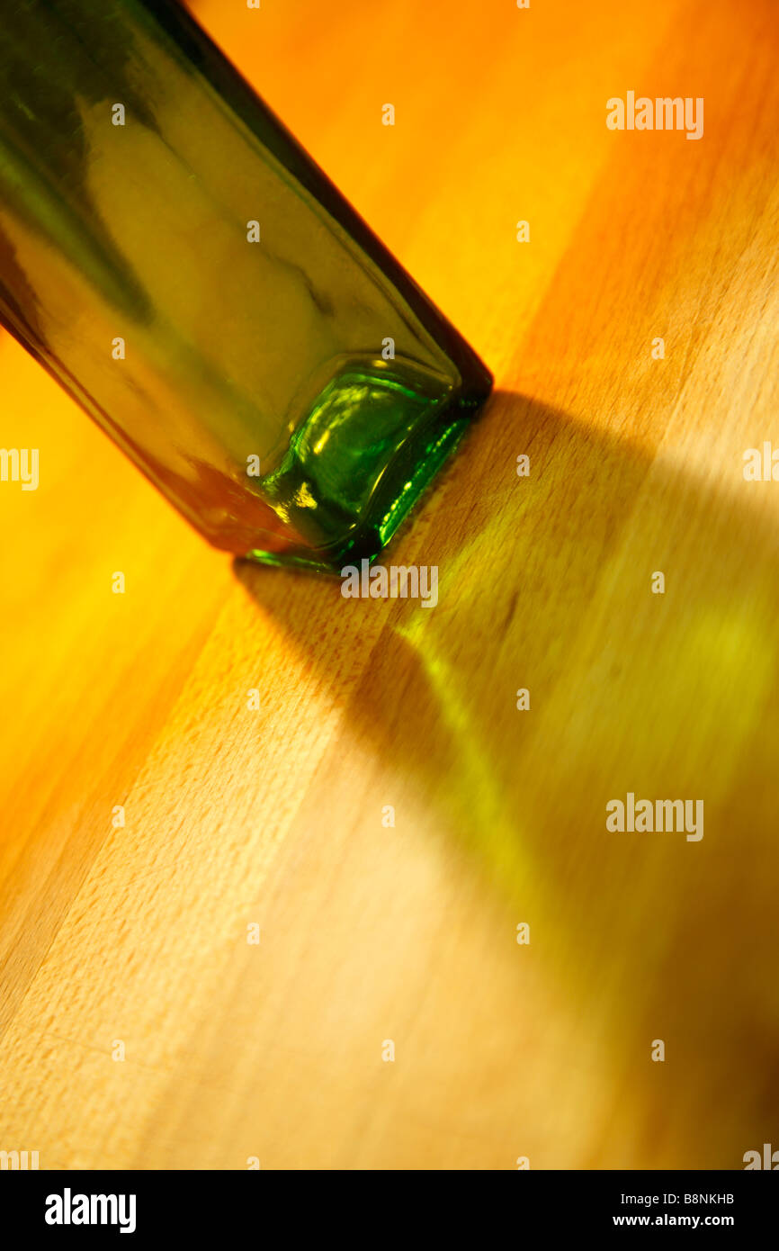 Une bouteille en verre vert sur une surface en bois Banque D'Images