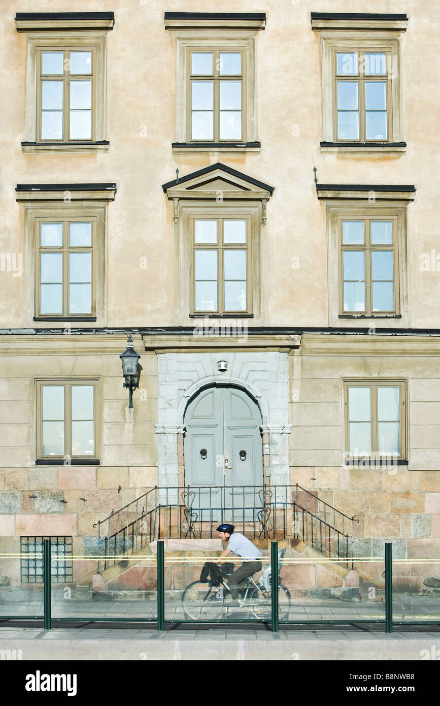 La Suède, Stockholm, bicyclist riding en face de l'immeuble Banque D'Images