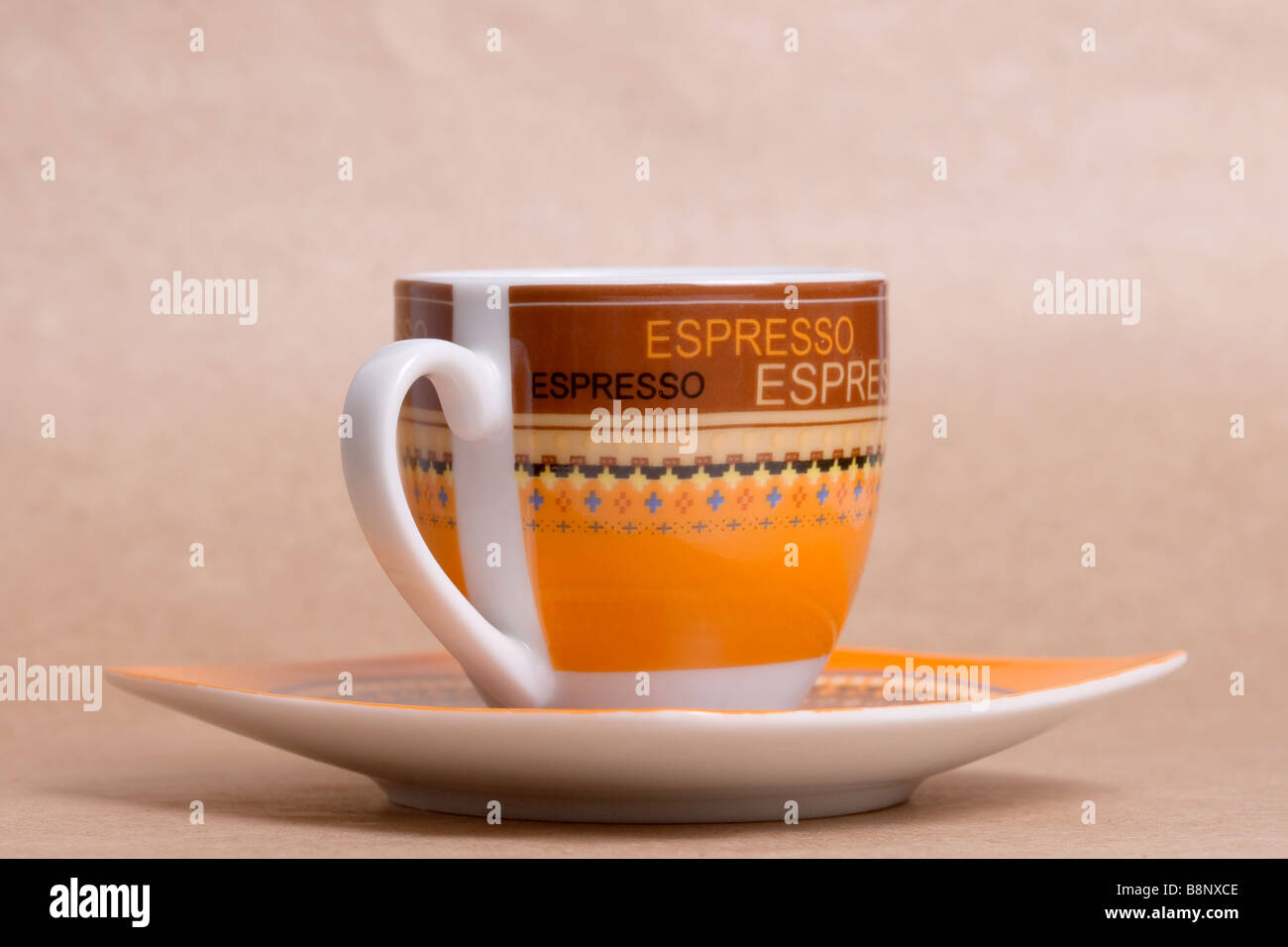 Espresso cup orange sur fond ocre Banque D'Images