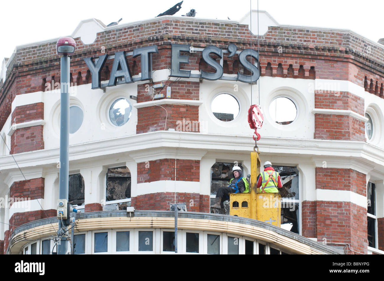 Deux travailleurs de la construction d'examiner les dommages causés par l'incendie de Yates's Wine Lodge de Blackpool, Angleterre Banque D'Images