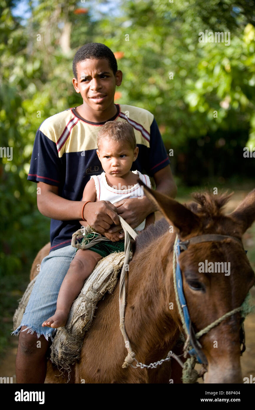 Jeune homme avec boy sur l'équitation, la République Dominicaine Banque D'Images