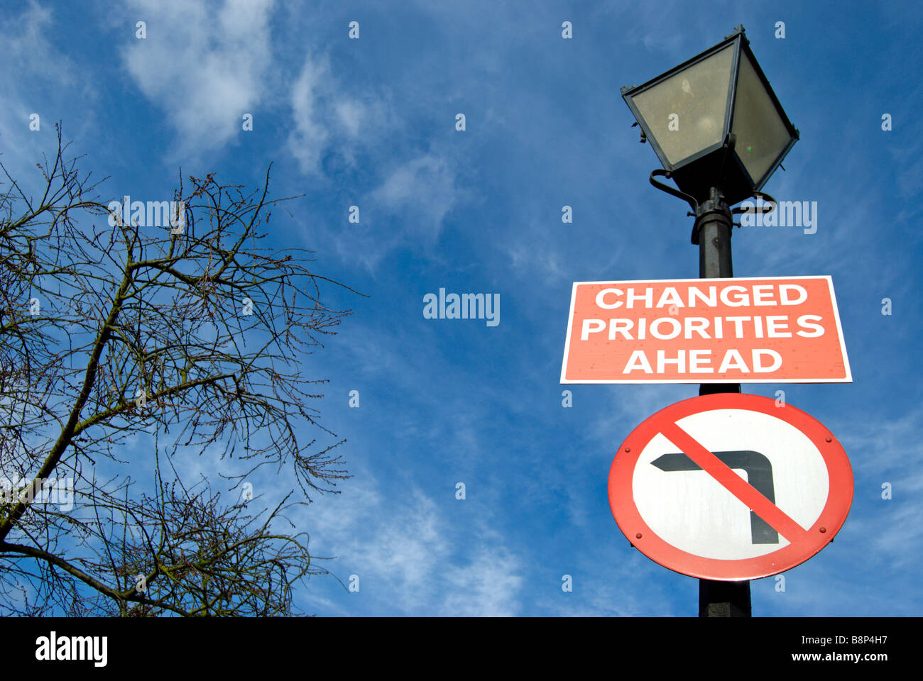 La signalisation routière fixé sur un lampadaire indiquant des changements de priorités de l'avant et pas de virage à gauche Banque D'Images