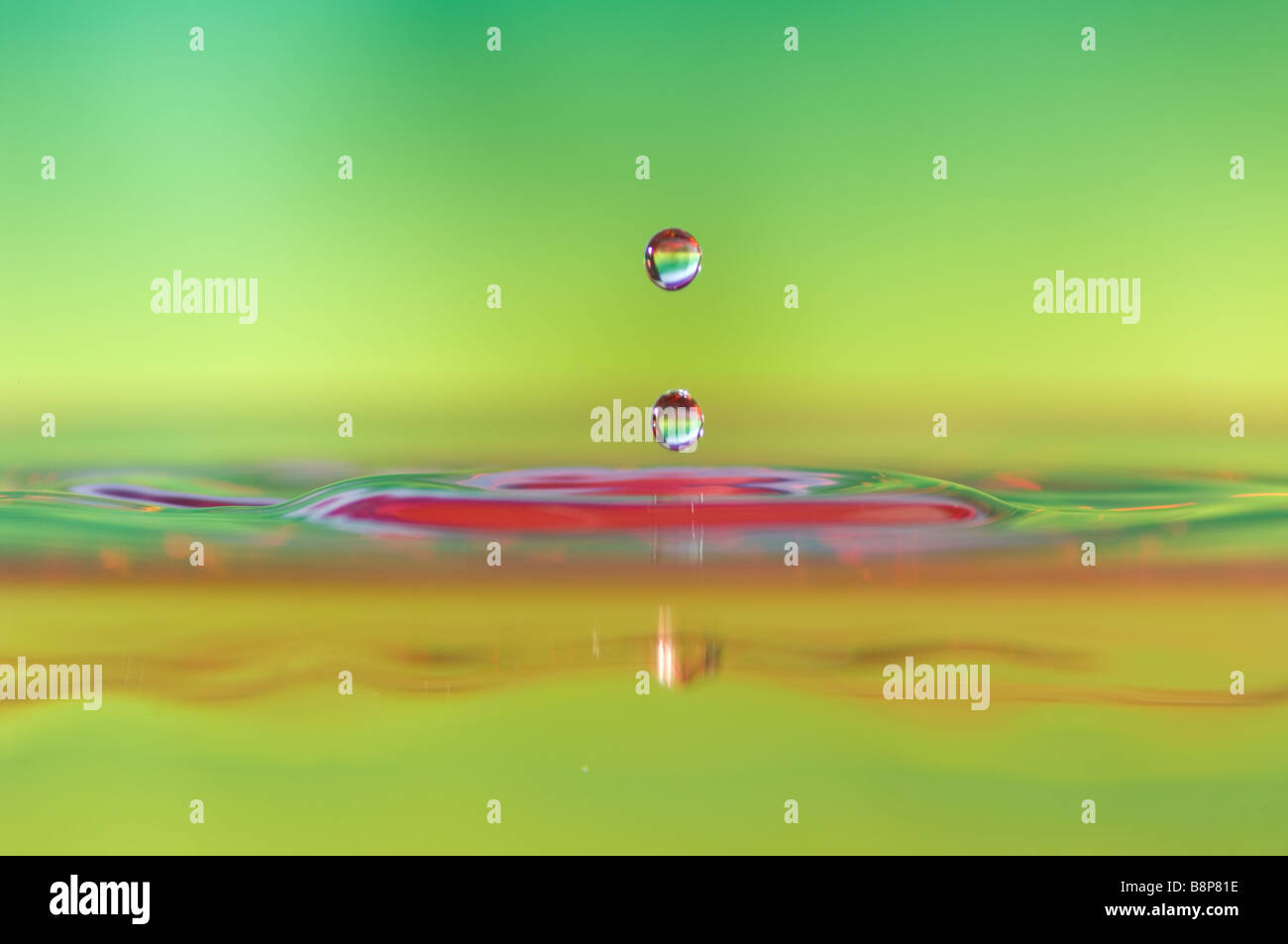 Les gouttelettes d'eau à grande vitesse, des réflexions de fond de couleurs vibrantes capturé dans les gouttelettes et les perturbations dans l'eau. Banque D'Images