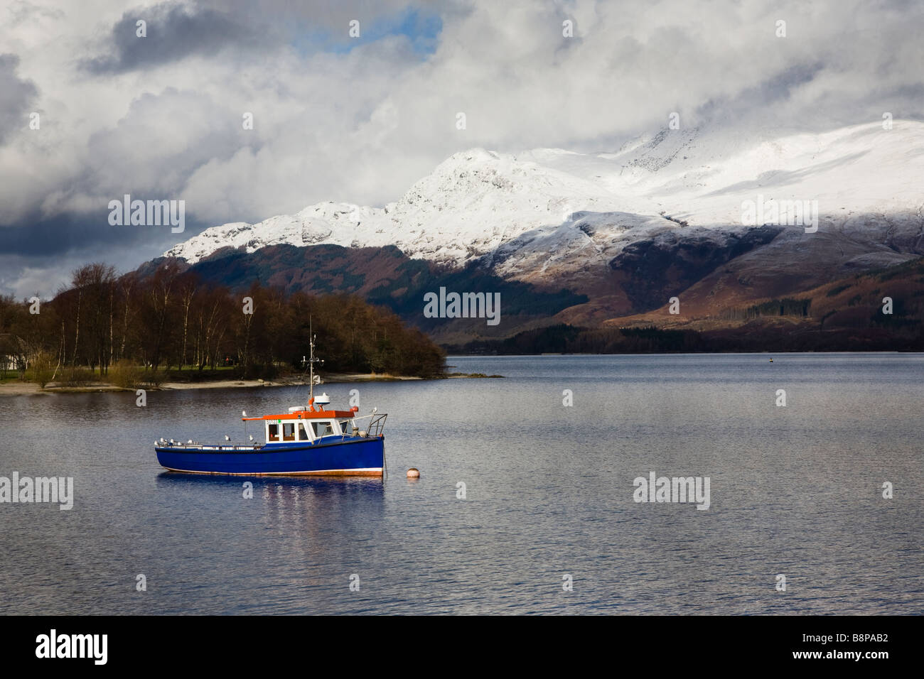 Petit bateau sur le Loch Lomond avec Ben Lomond couvertes de neige dans l'arrière-plan, Ecosse, Royaume-Uni Banque D'Images