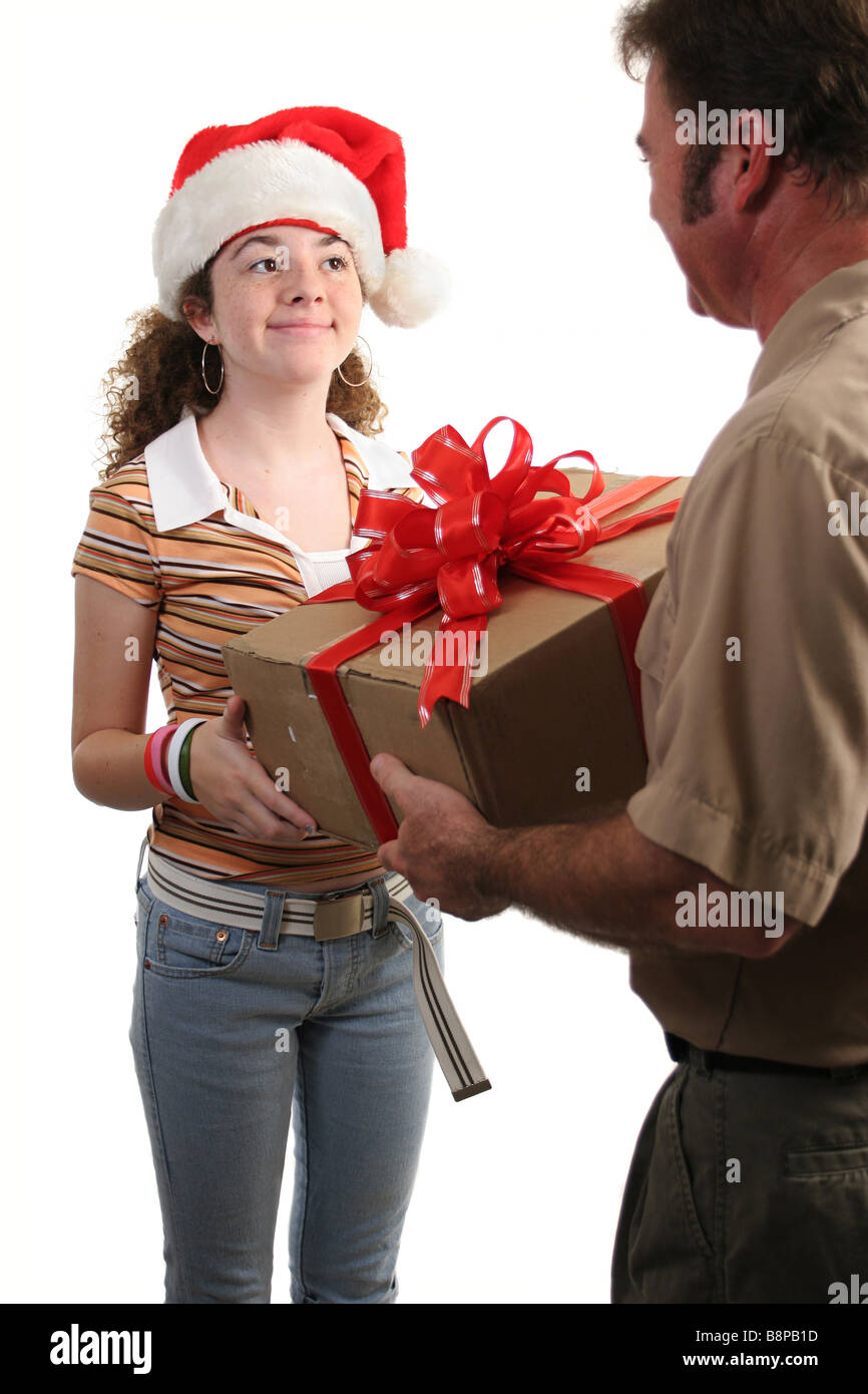 Une fille dans un Santa hat recevoir un cadeau par la poste l'accent sur fille isolée Banque D'Images