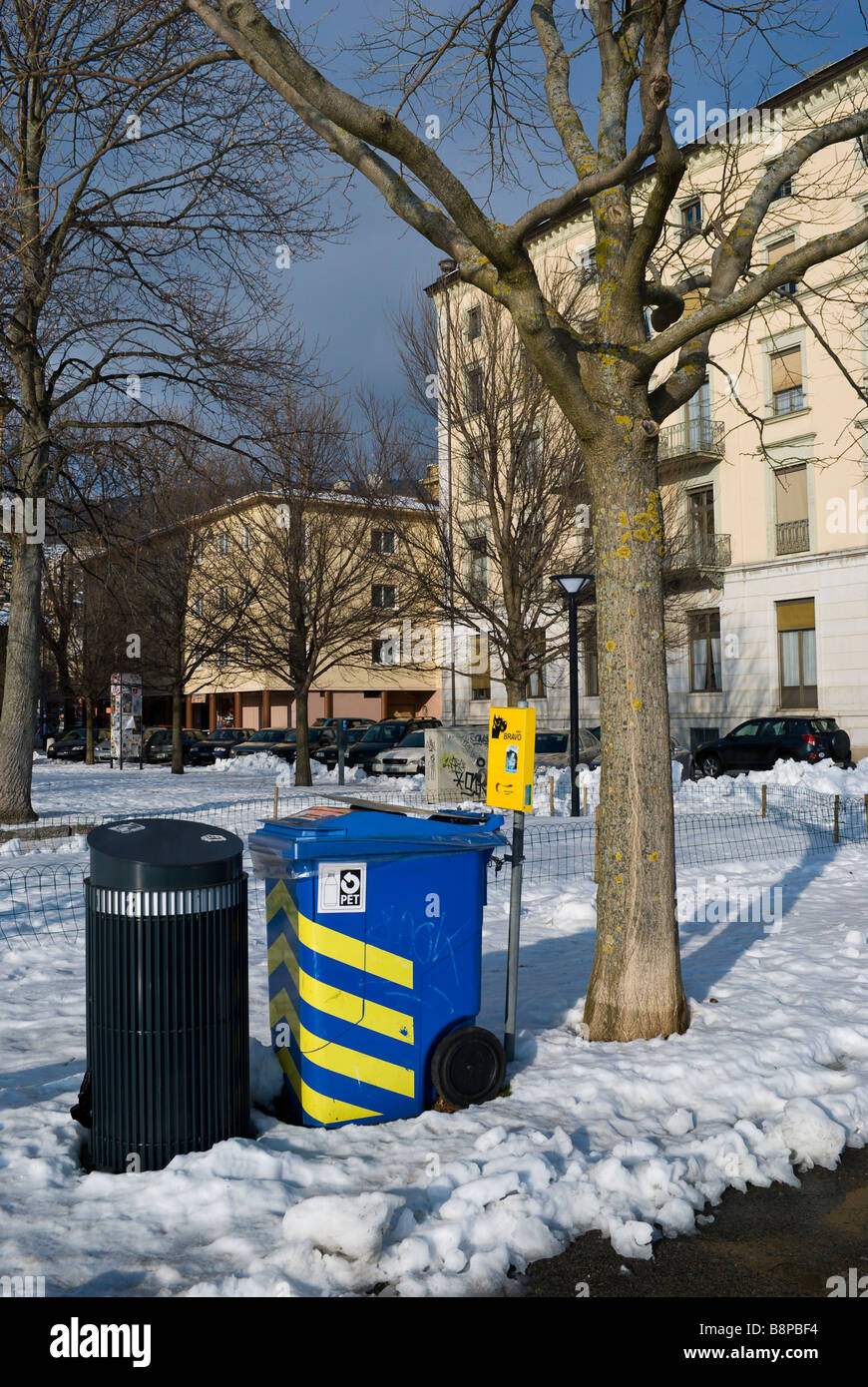 Un bac de recyclage est assis à côté d'une ville poubelle entouré par la neige ; Neuchâtel Suisse Banque D'Images