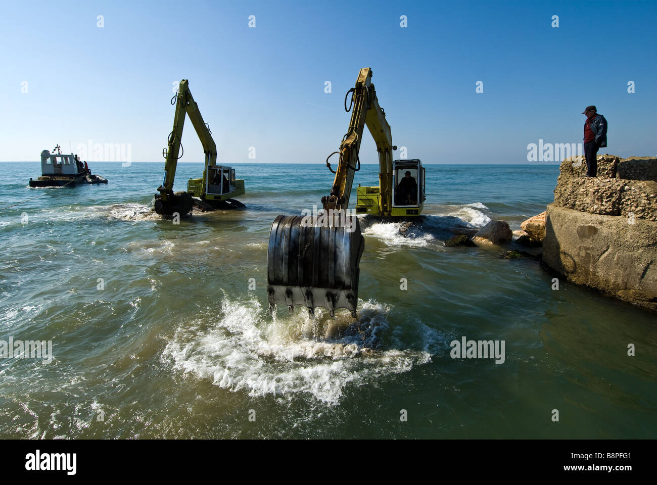 Diggers en action dans la mer à Sabaudia en Italie Banque D'Images
