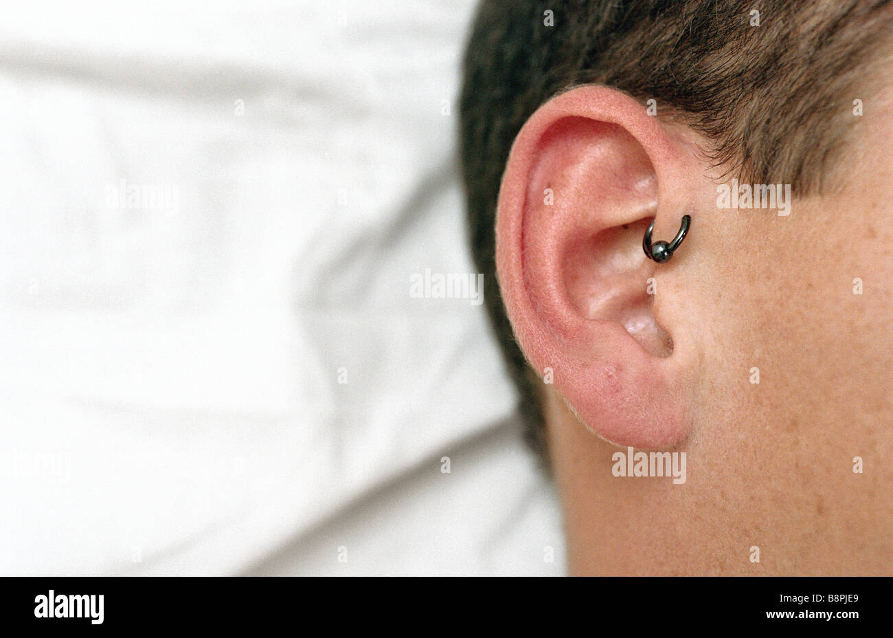 Jeune homme avec helix avant le perçage des oreilles, close-up Banque D'Images