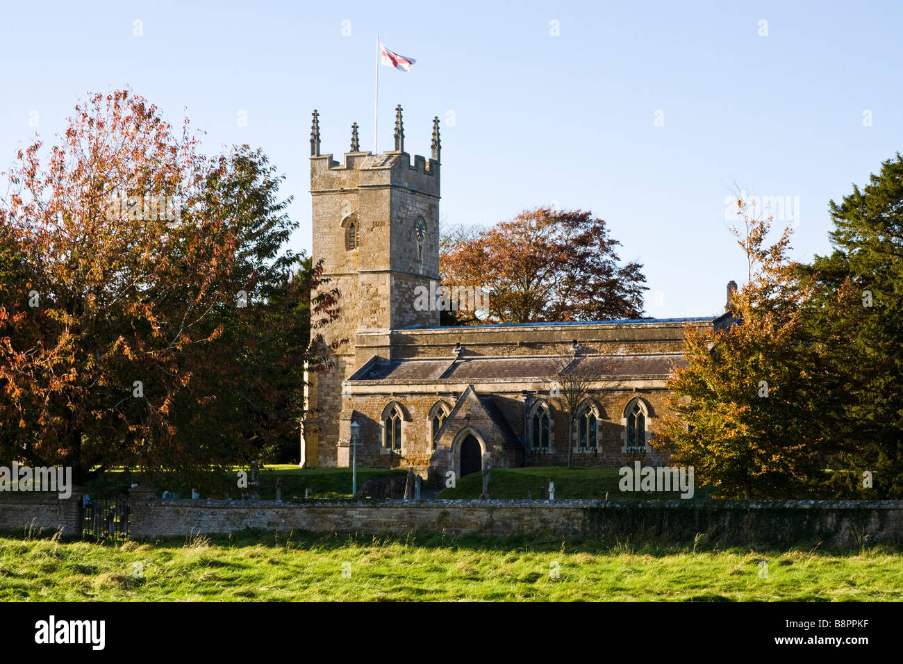 La lumière du soleil du soir qui tombe sur l'église St Andrews dans le village de Cotswold, Kingham Oxfordshire Banque D'Images