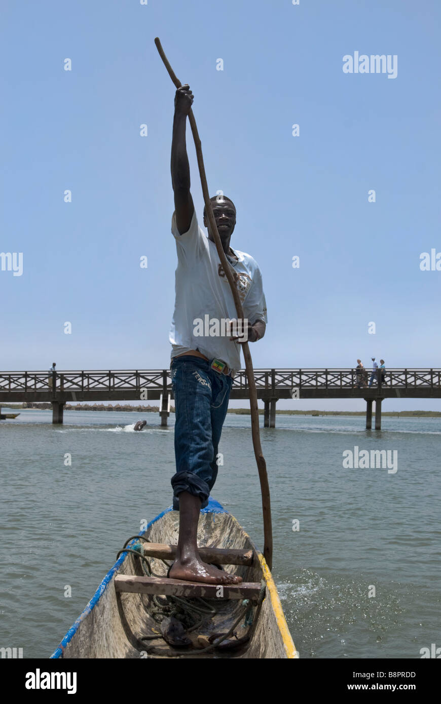 L'homme de l'Afrique de l'aviron dans une forme de banane bateau sculpté à la main à Joal fadiouth Sénégal Afrique de l'Ouest Banque D'Images
