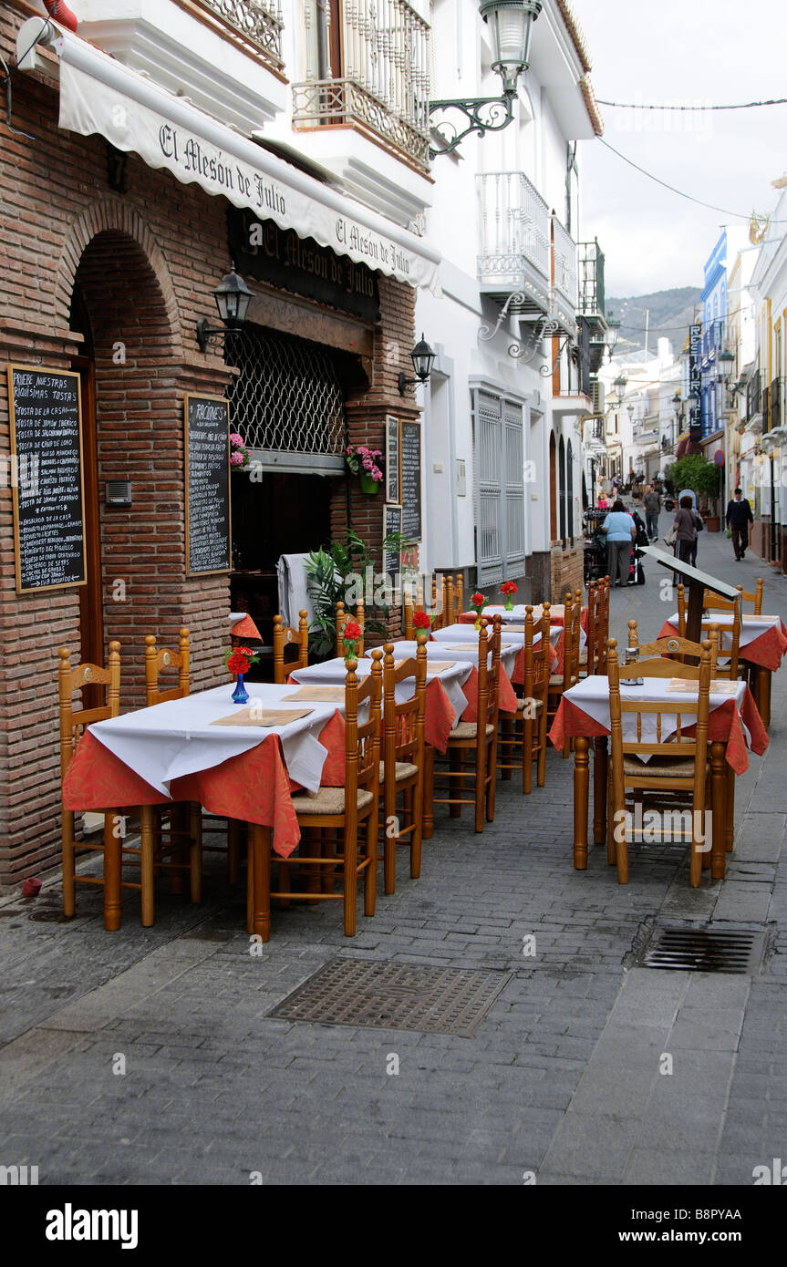 Restaurant vide et tables inoccupées désarmé et prêt pour les dans une rue de la ville de Nerja, Espagne du sud Banque D'Images