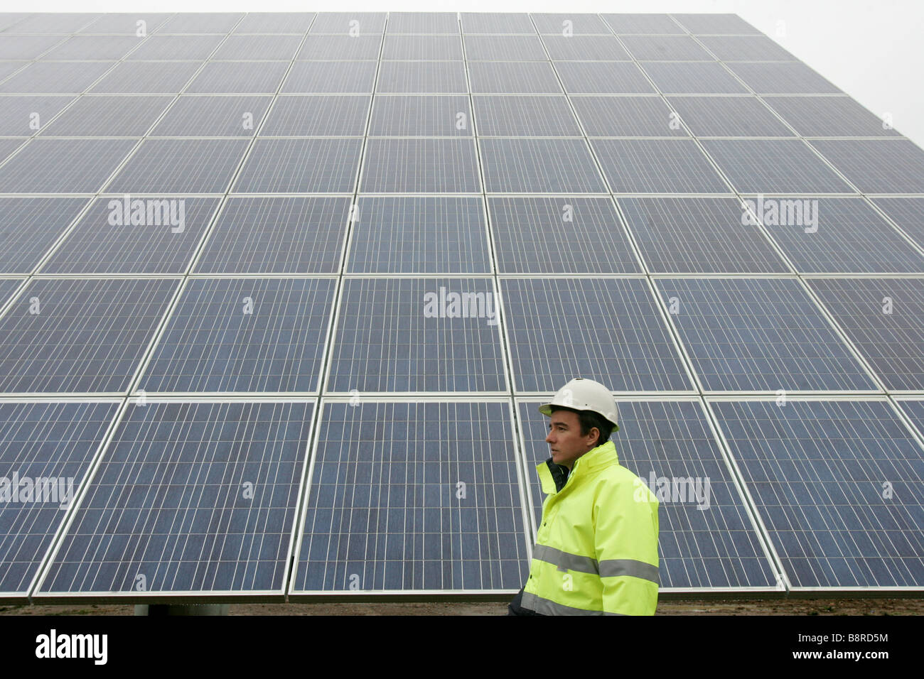 L'homme à côté d'un panneau solaire énergie géant. Banque D'Images