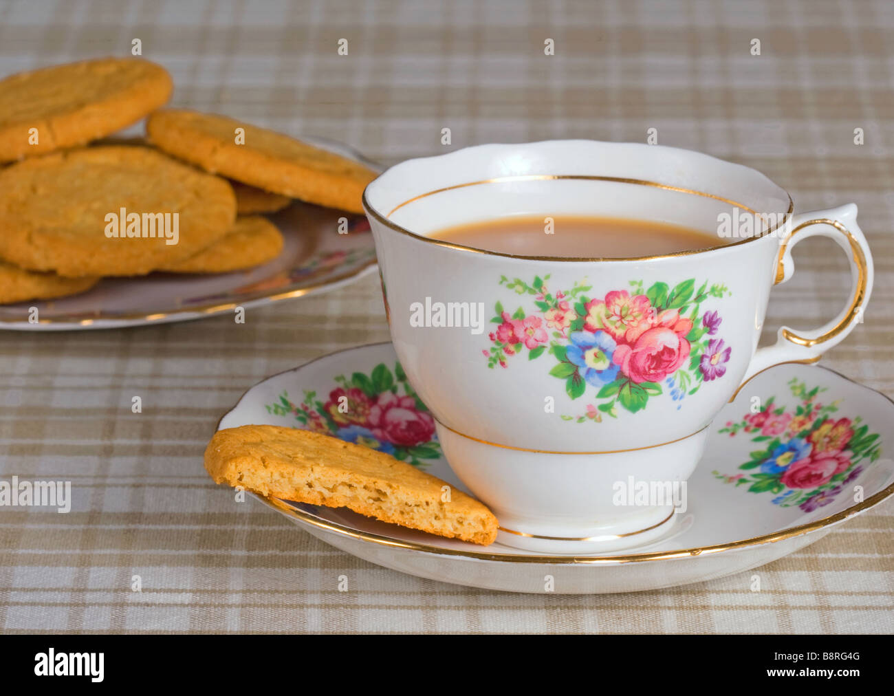 Une tasse de thé avec quelques biscuits Banque D'Images