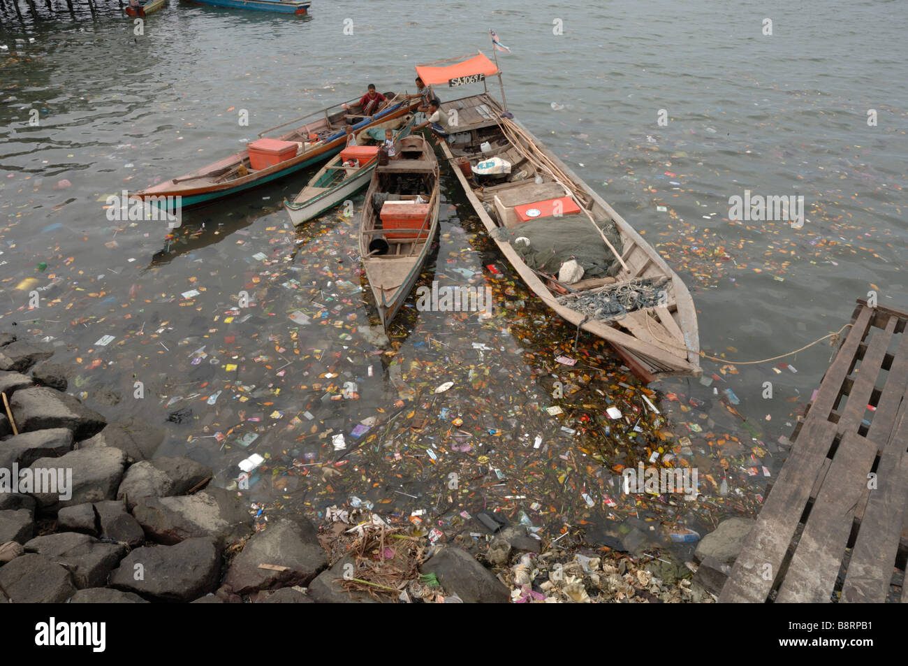 Bateaux de pêche en bois entourée de litière dans Sabah Malaisie Bornéo Semporna Harbour en Asie du sud-est Banque D'Images