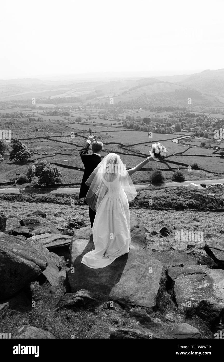 Mariée et le marié sur côté montagne forme à la recherche dans la distance Banque D'Images