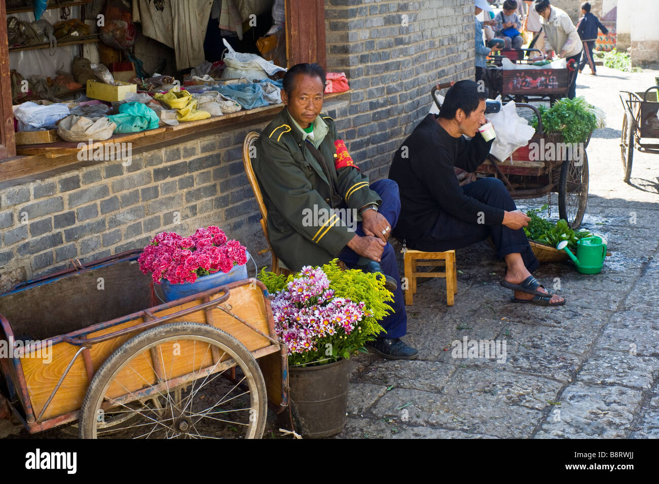L'homme en uniforme militaire vente de fleurs dans la région de Lijiang, Yunnan Province, China. Banque D'Images
