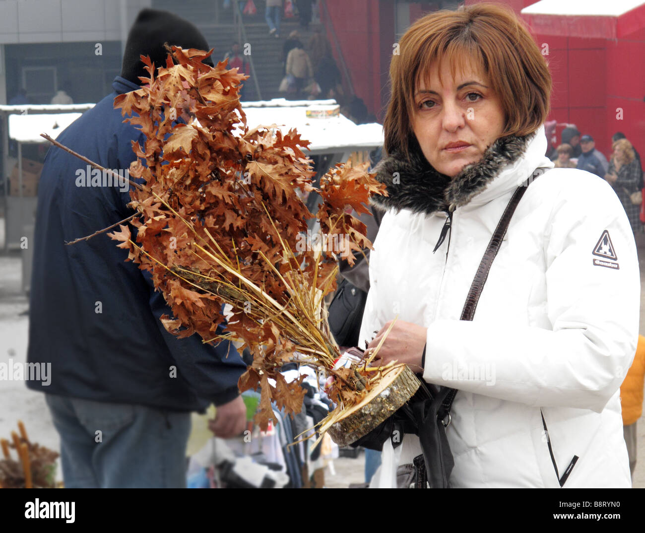 Femme avec des chrétiens orthodoxes de Noël un rameau de chêne sec avec des feuilles Banque D'Images