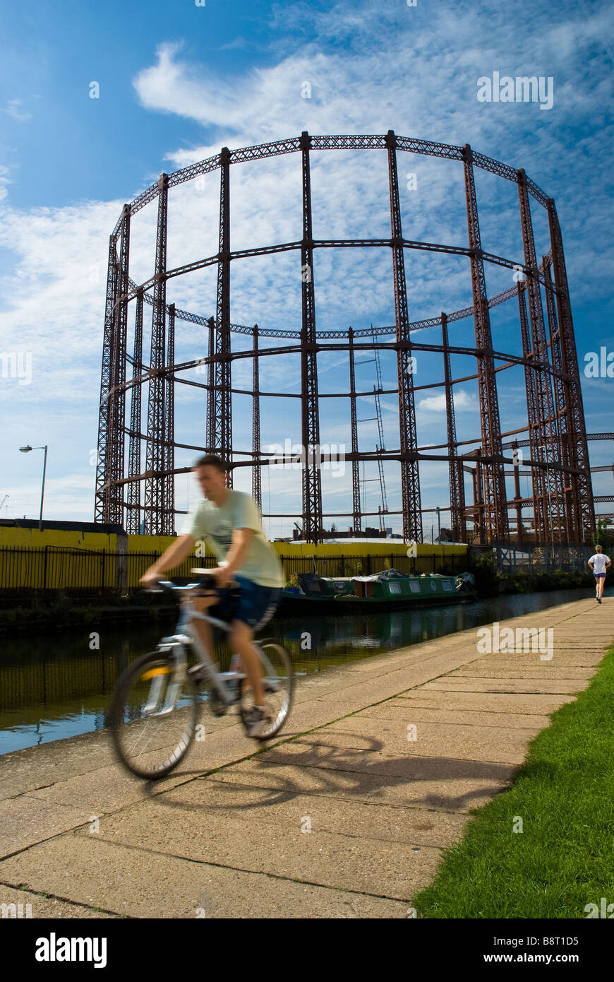 Un cycliste chevauche son vélo le long du canal près de Regent Mile End et le parc Victoria, à l'Est de Londres, Angleterre. Banque D'Images