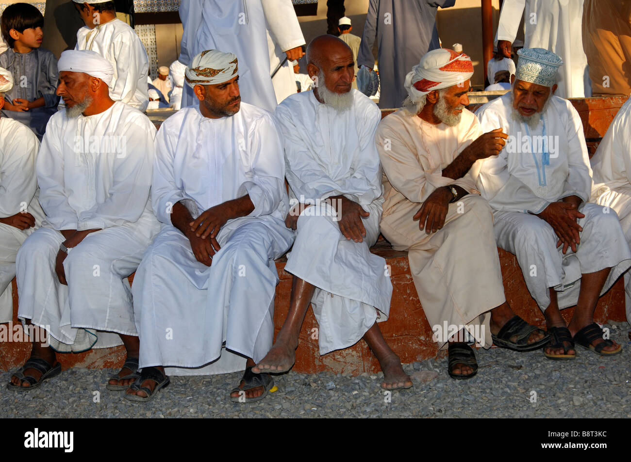 Groupe d'hommes omanais dans le costume national et une kummah Dishdasha cap ou d'un turban sur la tête mussar, Nizwa, Sultanat d'Oman Banque D'Images