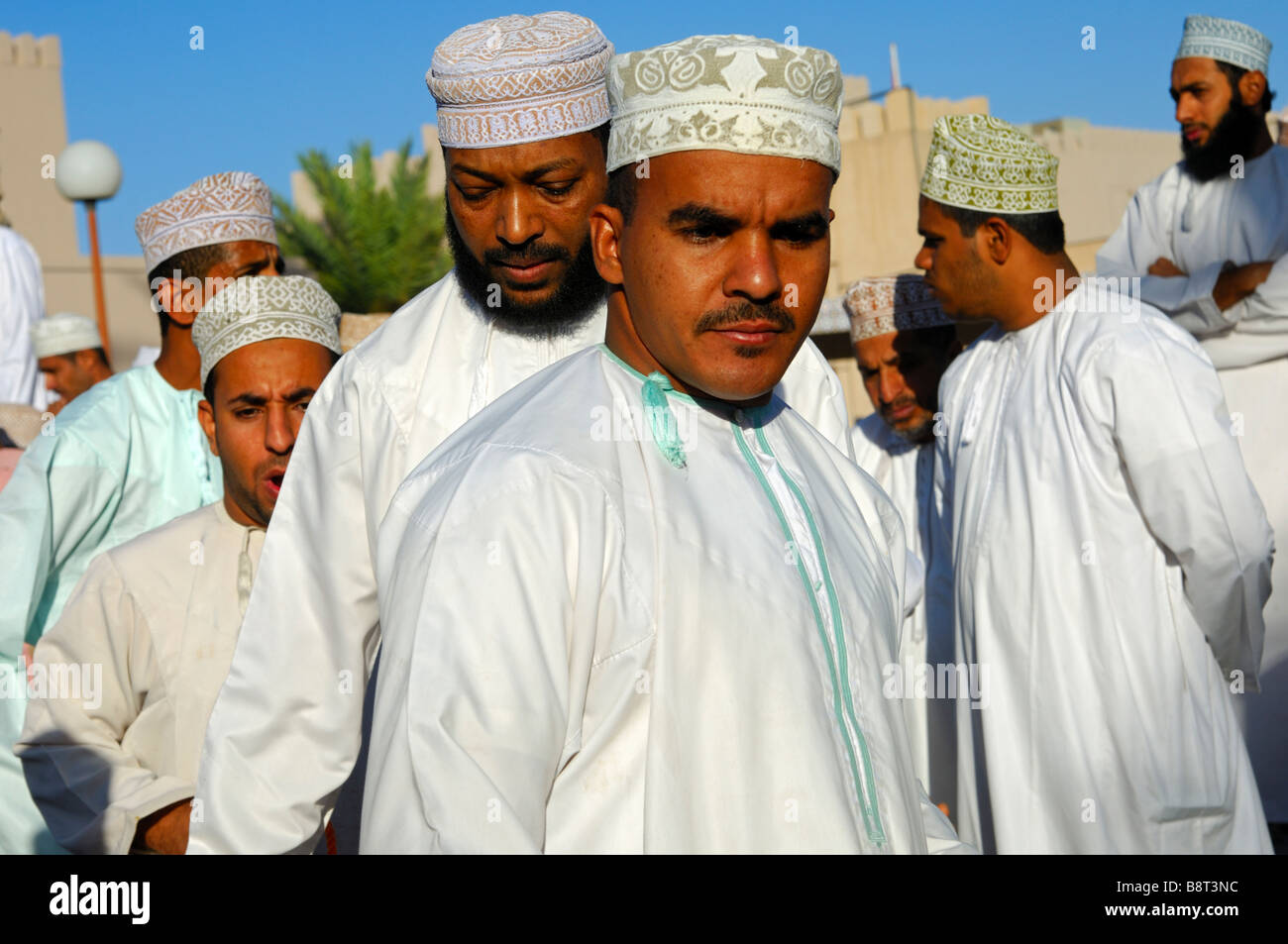 Les hommes dans l'Omanais costume national Dishdasha et le kummah cap sur la tête, Nizwa, Sultanat d'Oman Banque D'Images